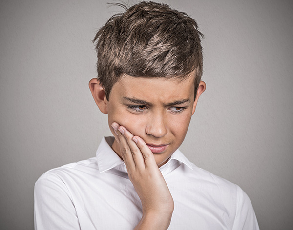 Young boy with toothache pain.