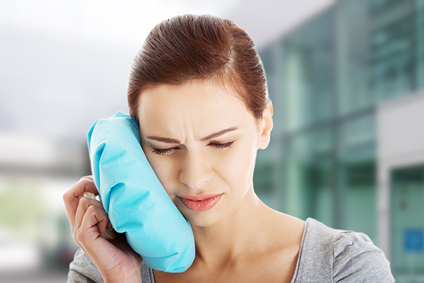 A woman with pain from a dental emergency.