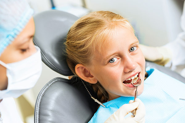 A child at the dentist being checked for tooth decay