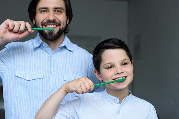 Father and son who appreciate the importance of dental hygiene brushing their teeth