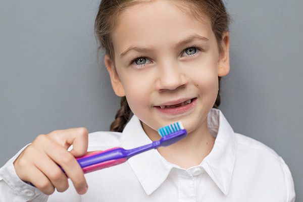 A child brushing their teeth to help keep healthy baby teeth