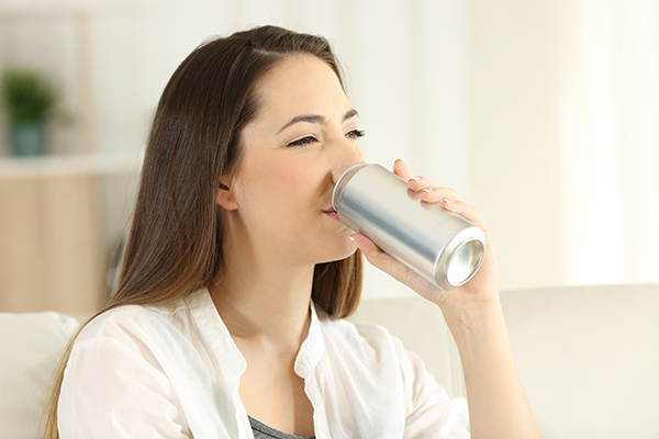 A woman in need of protecting tooth enamel drinking soda